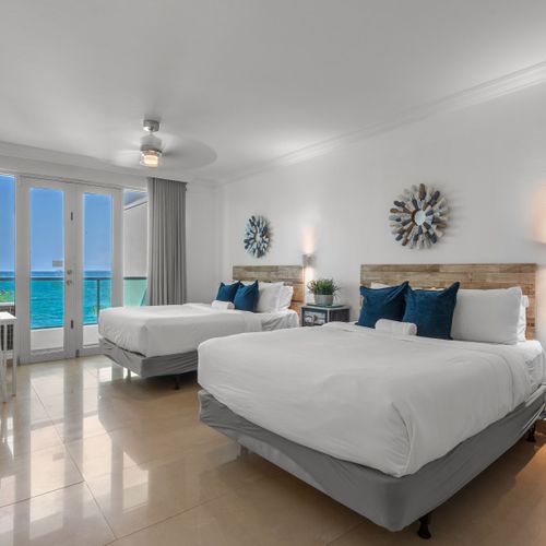 This well-designed room combines comfort and convenience, with two plush beds, a compact dining set, and direct access to a balcony boasting picturesque ocean views.