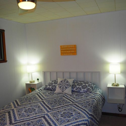 Bedroom #1:  features a queen-size bed, nightstands with lamps, ceiling fan, chair, dresser, closet, and full-length mirror.