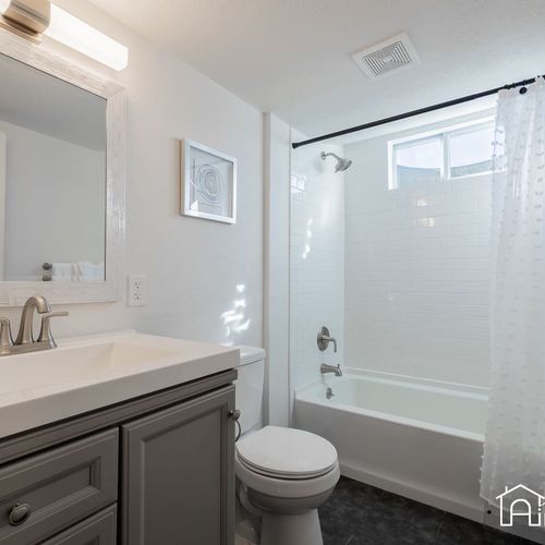 Experience spa-like amenities in the fully remodeled bathroom featuring a large tub/shower combo, extended modern vanity and ambient lighting.