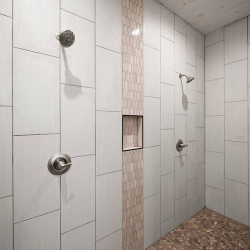 Huge walk-in shower with multiple shower heads.