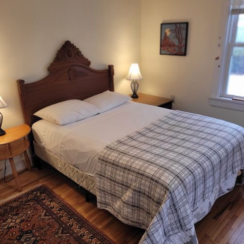 Bedroom #1 (main floor):  features a full-size bed, table, chair, dresser, and closet.