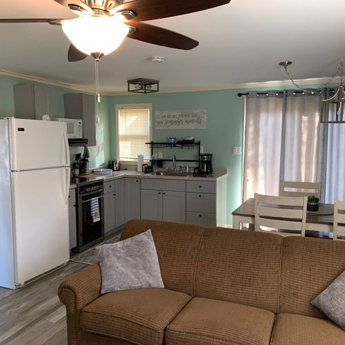 Overall:  living room with dining area and kitchenette in the background.