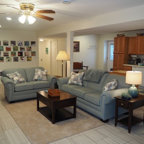Living room:  the apartment has a very comfortable living room with a sleeper sofa, comfy chair, ceiling fan, table, and television.