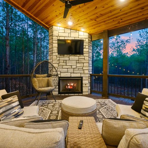 The covered patio houses an oversized outdoor sofa and a gas fireplace.