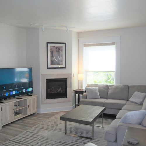 Living room:  gorgeous living room that features a gas fireplace and a large television with live streaming via hulu, netflix, and disney+.