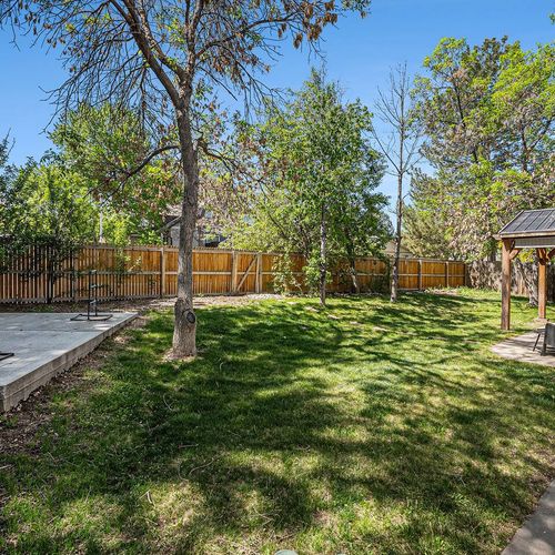 Sunny backyard oasis with covered patio—perfect for family cookouts and evening chats.