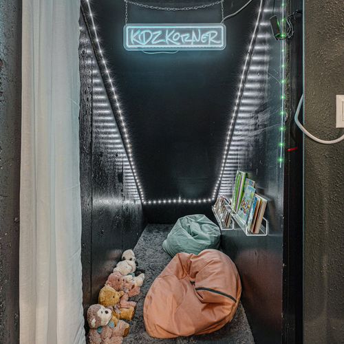 Under the stairs, discover a dedicated kid's space adorned with bean bags and shelves of colorful books.