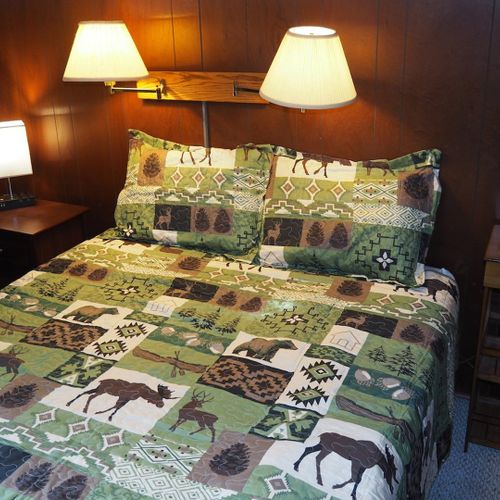 Bedroom #1:  features a queen-size bed, dresser, chair, lamps, and a ceiling fan.