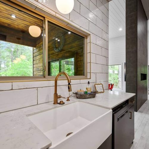The sink is accompanied by a large window overlooking the patio.