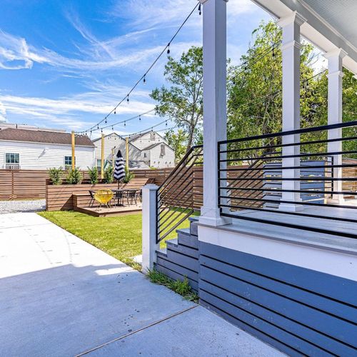 Covered rear porch w/ deck seating & a spacious backyard to unwind.