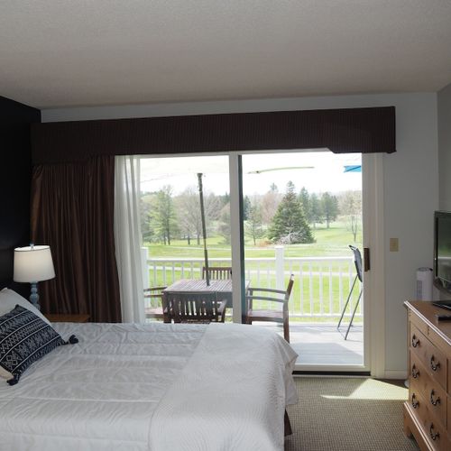 Guest bedroom:  features a queen-size bed, private entrance from the deck, nightstands with lamps, a dresser, closet, chair, and its own television.