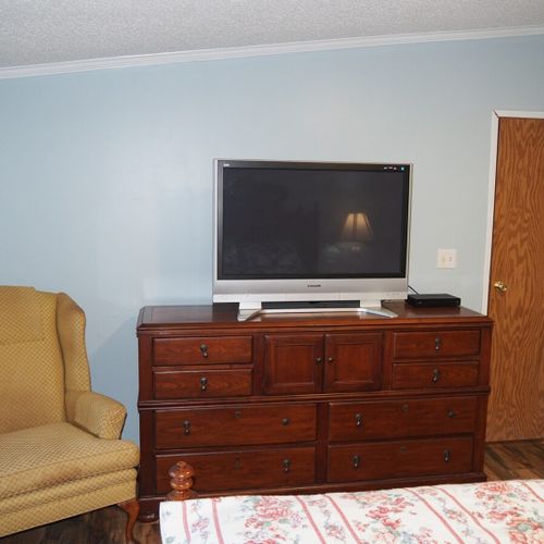 Bedroom #1 (master bedroom):  another angle showing the chair, one of the dressers, the television, and the bedroom door.
