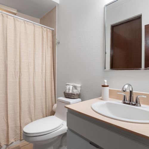 Enjoy a well-maintained bathroom featuring a spacious sink and all the essentials for your comfort.