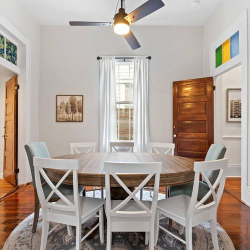 Sun-lit dining nook w/ an 8-seat table & wood accents — perfect for shared meals.