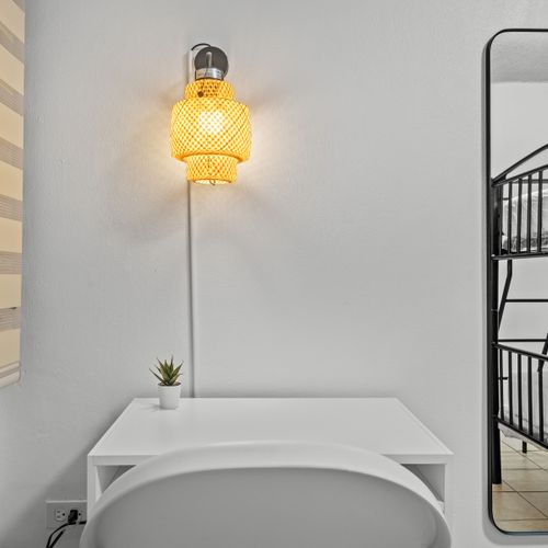 This intimate workspace, tucked under the bunk bed, is an ideal spot for peaceful reading or browsing, with minimalist decor and a modern vibe.