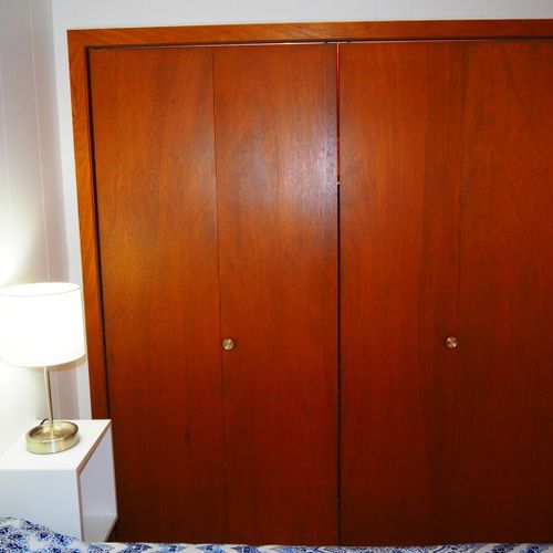 Bedroom #1:  features a queen-size bed, nightstands with lamps, ceiling fan, chair, dresser, closet, and full-length mirror.
