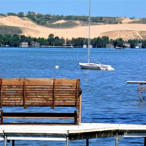 Overall:  the private dock on little glen lake with the sleeping bear dunes in the background.
