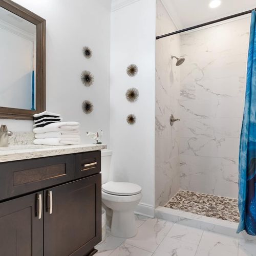 Bathroom w/ dark wood vanity & modern fixtures.