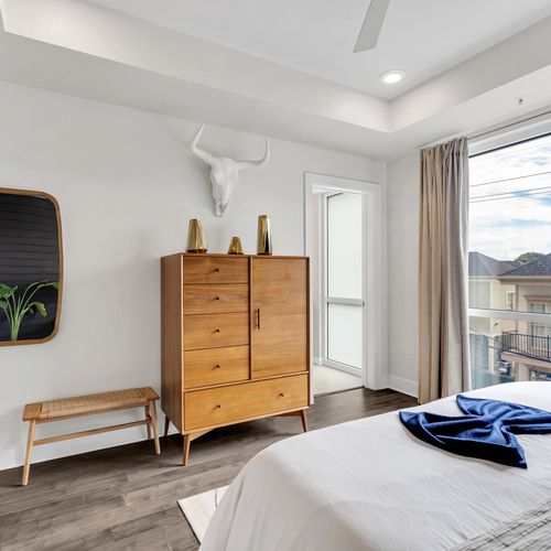 A bright and airy bedroom with mid-century modern accents and convenient bathroom access."