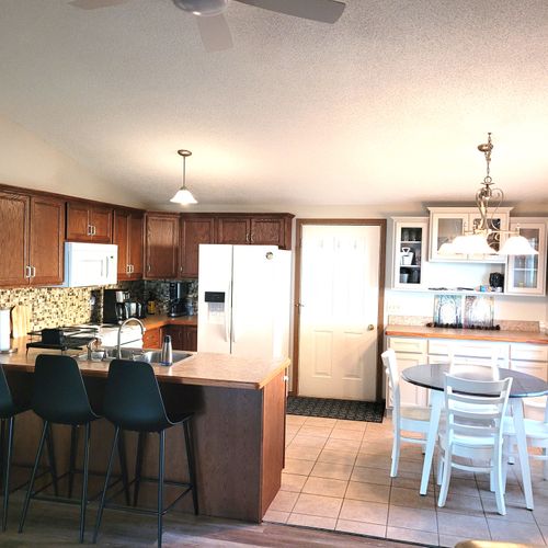 DINING AREA AND KITCHEN:  Looking into the dining area and kitchen from the living room.  (The door shown is the front entrance to the house.)