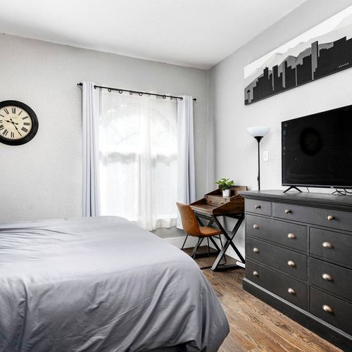 - relax and unwind on the plush king bed while streaming your favorite shows
- sleek desk setup makes it easy to catch up on work or plan your day
- stylish black dresser and skyline wall art add urban character and flair