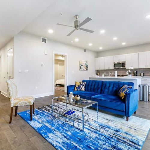 Bright living room w/ a bold blue sofa & plenty of space to relax or gather.