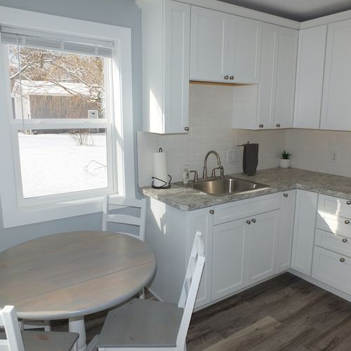 Kitchen:  the kitchen from another angle showing the kitchen sink, cupboards, and the cute little dining table.