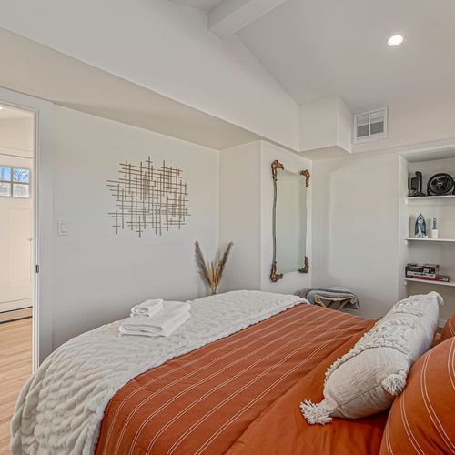 - earthy tones & a textured wall hanging bring warmth & calm to this restful bedroom retreat
- full length ornate mirror and decorative shelving add style and function to the cozy space
- crisp linens & layered pillows promise comfort & relaxation