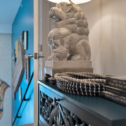 Striking stone lion sculpture brings cultural depth & artistic weight to the décor.