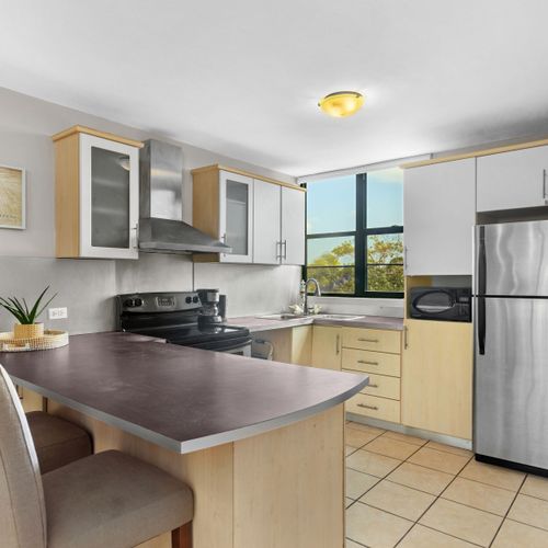 Modern and fully-equipped kitchen with a convenient breakfast bar for quick meals and social cooking.