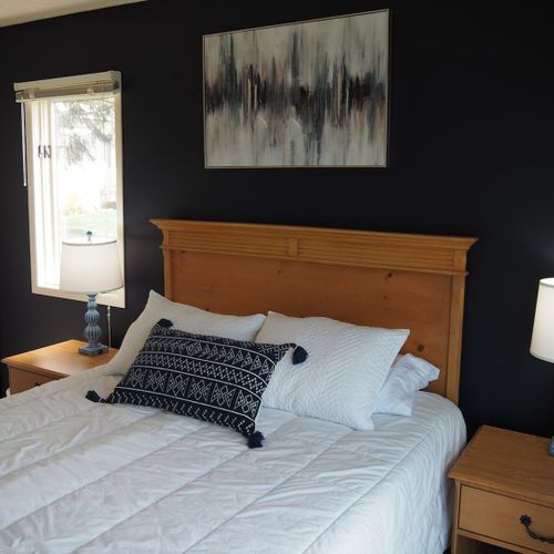 Guest bedroom:  features a queen-size bed, private entrance from the deck, nightstands with lamps, a dresser, closet, chair, and its own television.