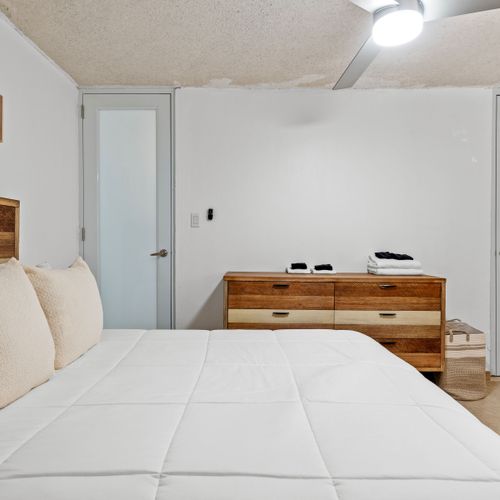 Relax in this inviting bedroom that combines modern comfort with a touch of rustic charm, highlighted by a spacious wardrobe and contemporary decor.