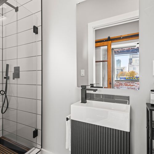 Modern design with black fixtures and a fresh, organized feel.