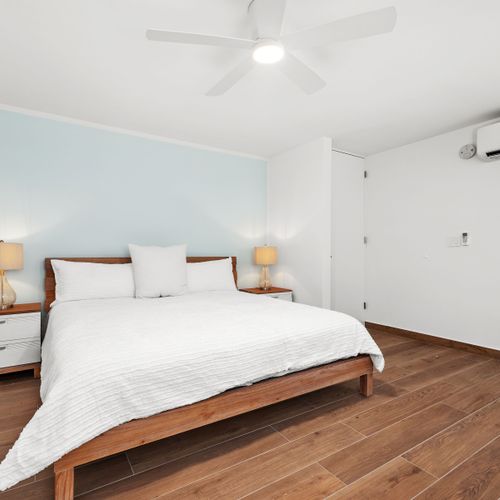Spacious bedroom with a stylish dresser, ceiling fan & A/C for comfort.