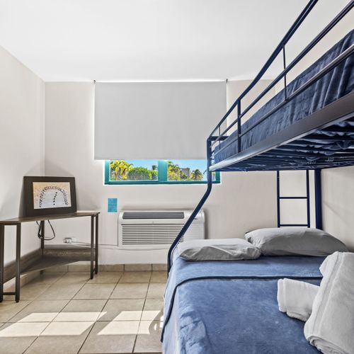 Stay in our minimalist room offering a comfortable bunk bed, ample lighting, and a picturesque view through the expansive windows.