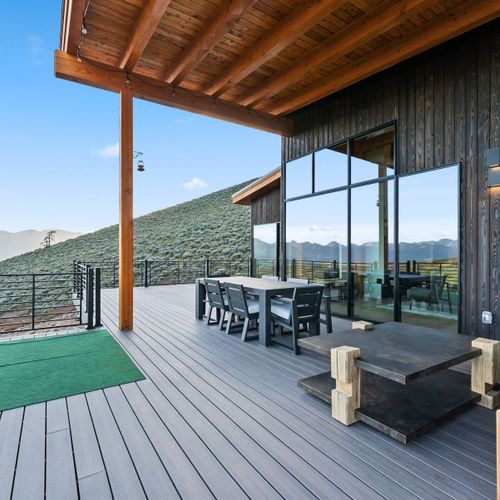 Open-air deck with cozy seating and serene mountain panorama surroundings.