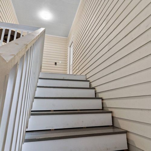 Bright staircase w/ white walls — clean, airy & easy to navigate.