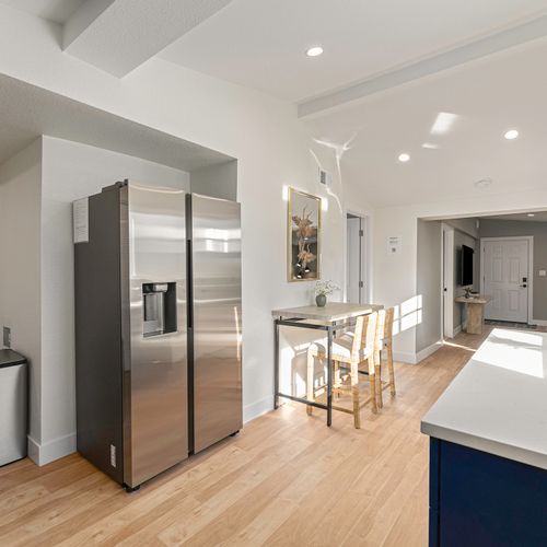 - enjoy breakfast or remote work at this cozy table basking in natural light
- modern stainless steel fridge and sleek floors give the space a fresh feel
- thoughtfully designed layout connects the kitchen, dining, and entry areas