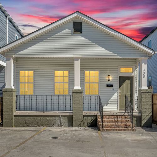 Charming exterior w/ classic porch & glowing windows — a welcoming first impression.
