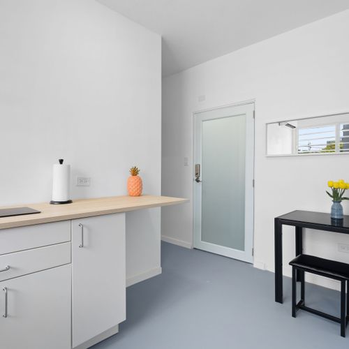 White cabinetry, essential appliances, and ample counter space make this kitchenette as functional as it is elegant.