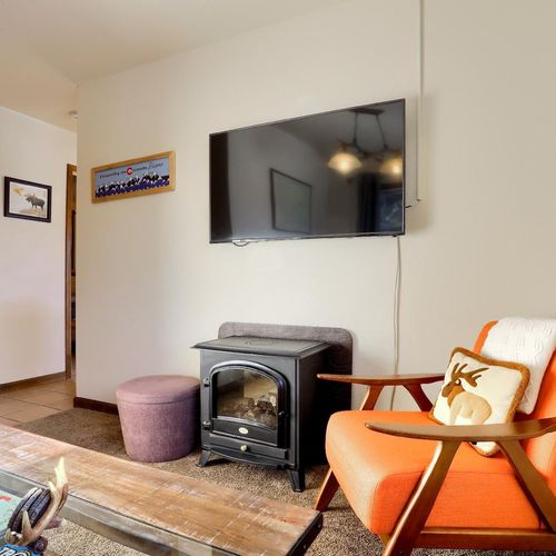 - kick back in the orange accent chair and enjoy your favorite shows on the flat screen tv
- compact electric fireplace adds warmth to chilly mountain evenings
- cabin inspired decor and art provide a fun touch of local flair