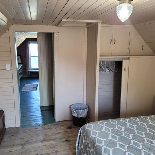 BEDROOM #3 (UPPER FLOOR):  Features a full-size bed, nightstand, dresser, mirror, baby crib, and closet.