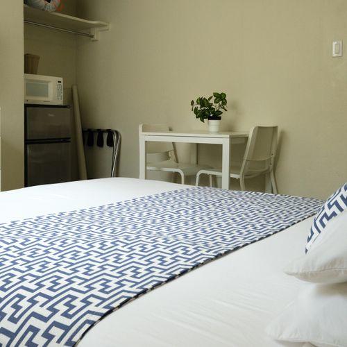 Unwind and enjoy! This spacious room offers a comfortable bed and a dedicated dining/workspace area, perfect for a relaxing stay or catching up on tasks.