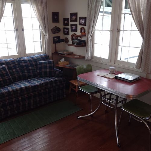 Living room:  the cabin has a cute little living room with a loveseat, dining table, and streaming television.