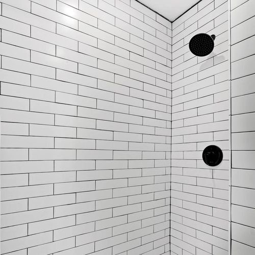 Sleek tiled shower w/ modern fixtures — clean & refreshing.