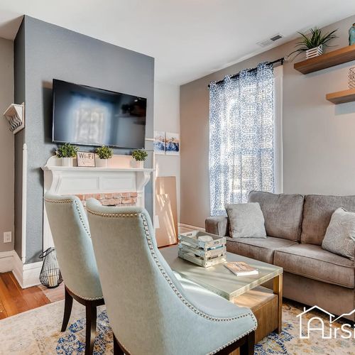- stylish living room with a mounted tv over the fireplace and bright natural light
- plush sofa and two accent chairs make this space perfect for gathering and lounging
- floating shelves and unique details bring warmth and charm