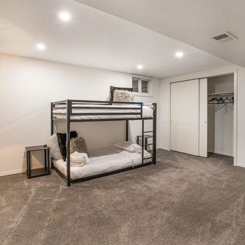 This downstairs bedroom features a twin-over-twin bunk beds, mounted 40" tv, ample closet space with extra room to stretch out.