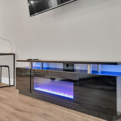 Sleek entertainment console w/ an electric fireplace for cozy evenings in.
