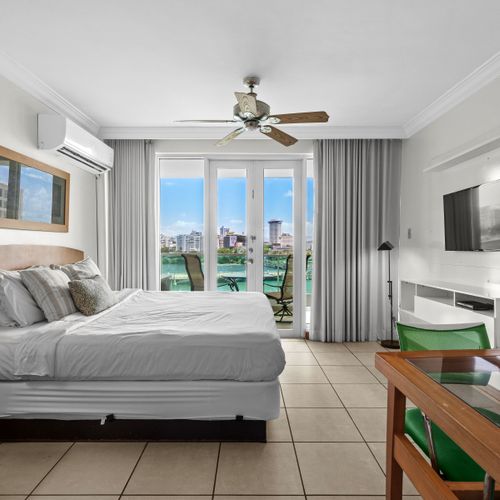Comfortable studio bedroom with a ceiling fan, TV, and direct access to stunning views.