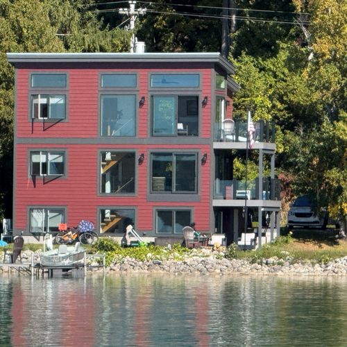 OVERVIEW:  The back of the house from out on Crystal Lake, highlighting the dock, backyard, and multiple decks
